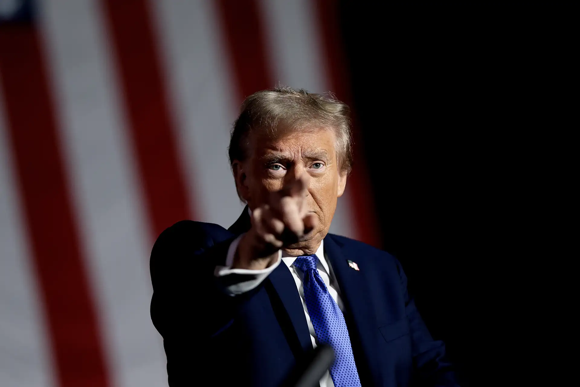 Donald Trump apontando pra frente, sério