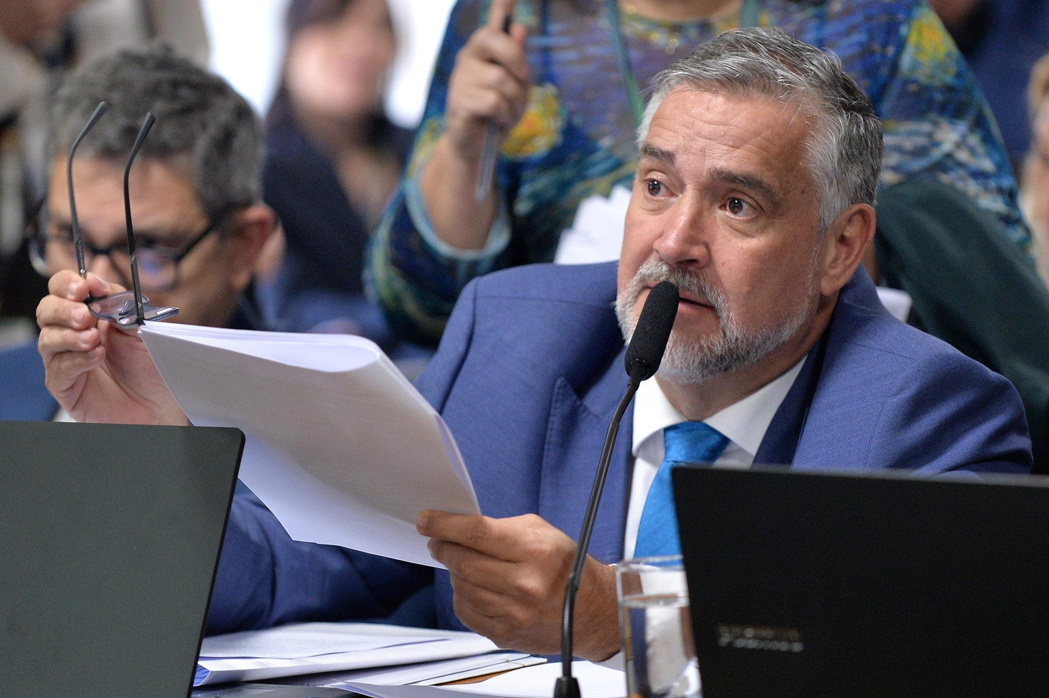 deputado Paulo Pimenta (PT-RS) falando em microfone e segurando papel, sério, sem olhar para a câmera