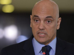 Alexandre de Moraes falando, sério, sem olhar para a câmera, em close, de terno e gravata
