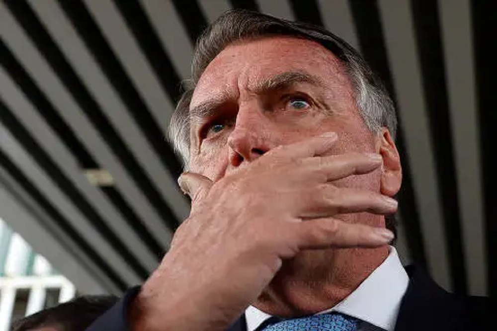 ex-presidente Jair Bolsonaro (PL) com a mão no rosto e expressão de medo, em close, em foto feita de baixo, ele sem olhar para a câmera