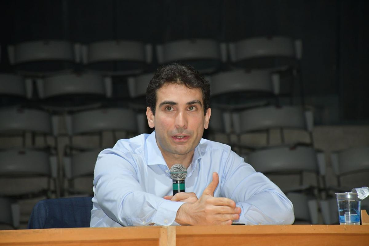 O presidente do Banco Central, Gabriel Galípolo, de roupa social clara, falando em microfone, sério