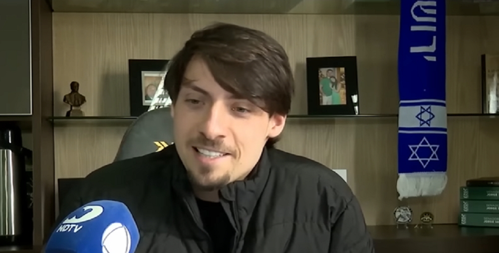 vereador Jair Renan Bolsonaro (PL) de roupa preta, falando sem olhar para a câmera