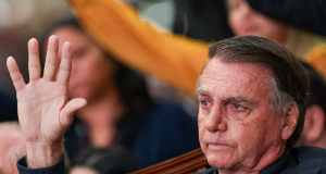 ex-presidente Jair Bolsonaro (PL) chorando com uma das mãos levantadas, sem olhar para a câmera
