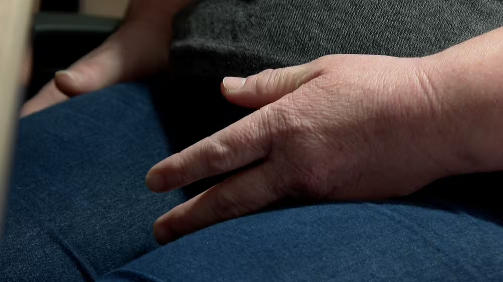 Mão de mulher apoiada em calça jeans