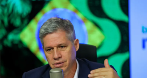 Paulo Teixeira, ministro do Desenvolvimento Agrário e Agricultura Familiar, sério, falando em microfone e gesticulando sem olhar para a câmera