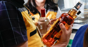 Pessoas segurando garrafas de bebida alcoólica