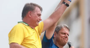 O ex-presidente Jair Bolsonaro (PL) e o governador de São Paulo, Tarcísio de Freitas (Republicanos), de mãos dadas e braços erguidos sorrindo sem olhar para a câmera