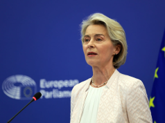 presidente da Comissão Europeia, Ursula von der Leyen, séria, falando, sem olhar para a câmera, de roupa social clara
