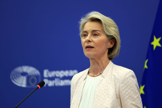 presidente da Comissão Europeia, Ursula von der Leyen, séria, falando, sem olhar para a câmera, de roupa social clara