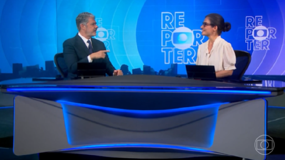 William Bonner e Renata Vasconcellos na bancada do Jornal Nacional, se olhando e falando