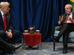 Donald Trump e Lula conversando, sentados frente a frente