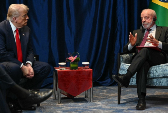 Donald Trump e Lula conversando, sentados frente a frente