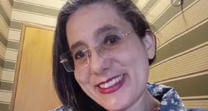 Luciana Mallon de óculos, sorrindo para a câmera