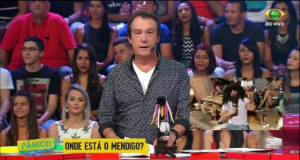 Emílio Surita na época do Pânico na Band, em pé, falando para a câmera, com a plateia atrás