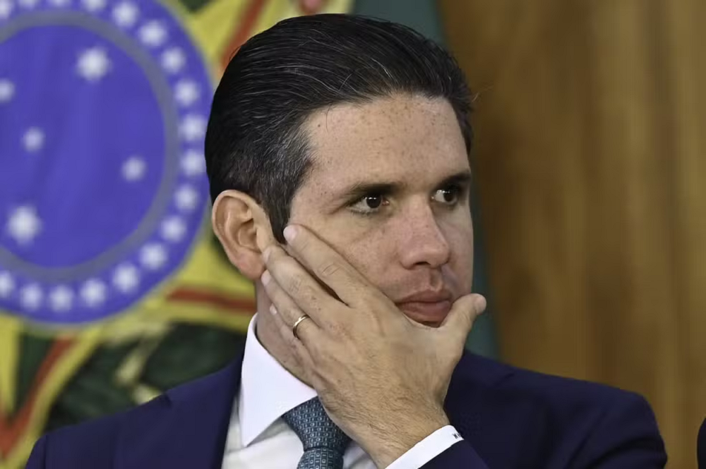 presidente da Cãmara dos Deputados, Hugo Motta, sério, com a mão no rosto, olhando para o lado