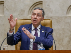 O ministro Luís Roberto Barroso, do STF (Supremo Tribunal Federal), falando e gesticulando, sentado, sem olhar para a câmera