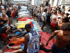 Corpos enfileirados após operação policial com pessoas em volta