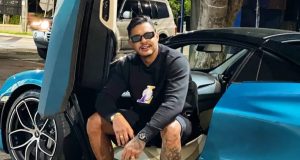 Hungria sentado em carro azul, de óculos escuros, posando para foto