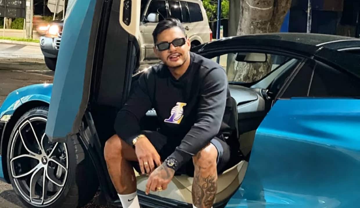 Hungria sentado em carro azul, de óculos escuros, posando para foto