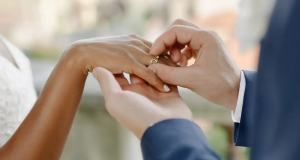Mão masculina colocando aliança em mão feminina