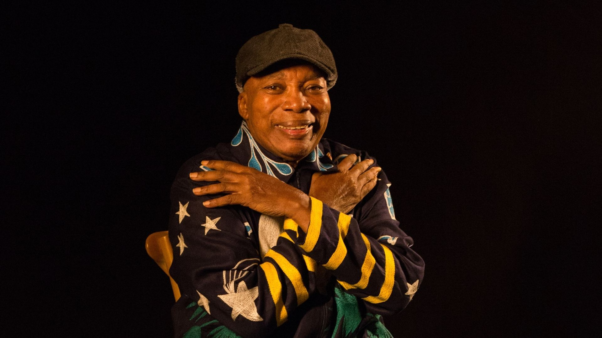 cantor Milton Nascimento sorrindo para a câmera se abraçando