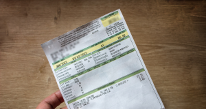 Mão masculina segurando conta de luz