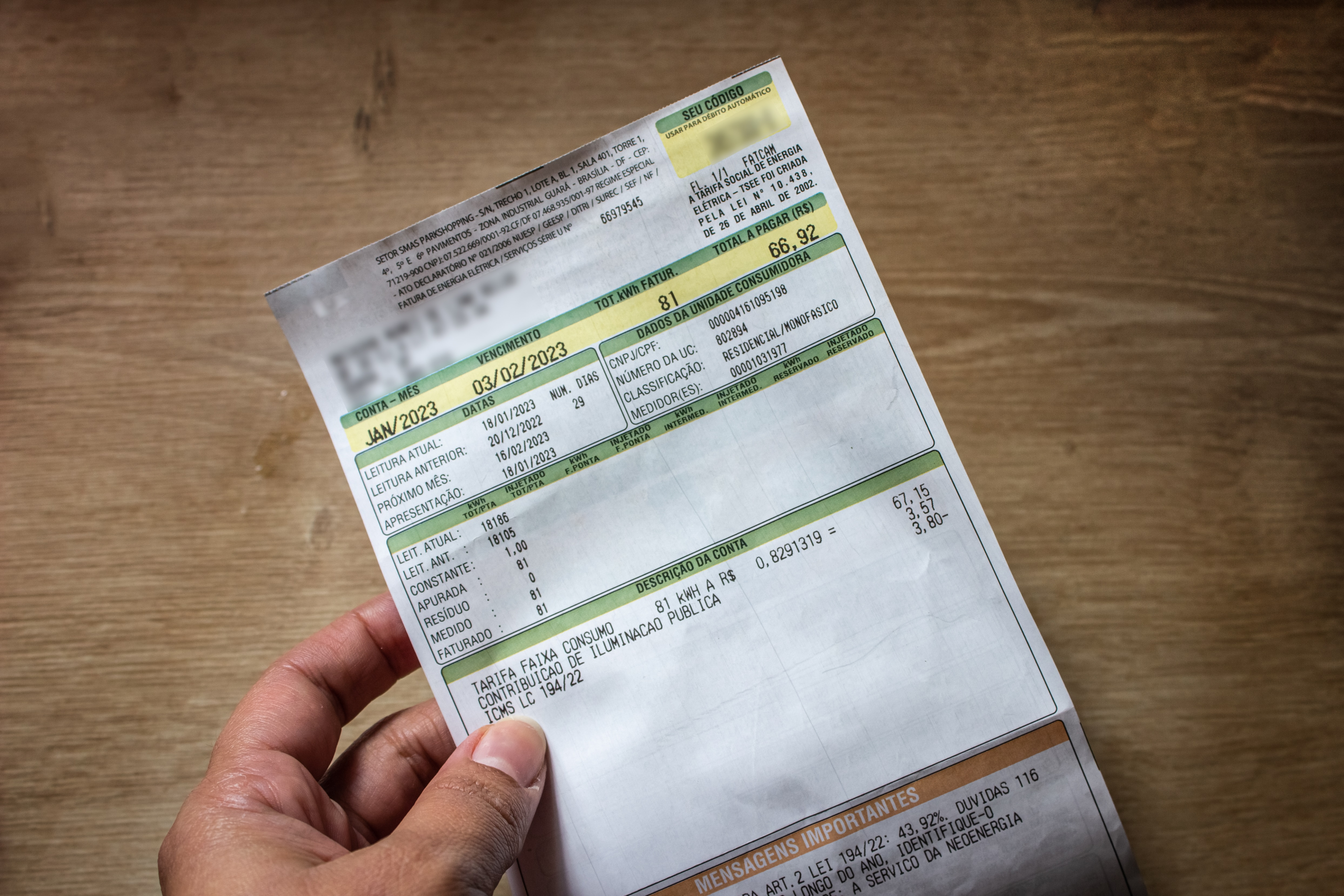 Mão masculina segurando conta de luz