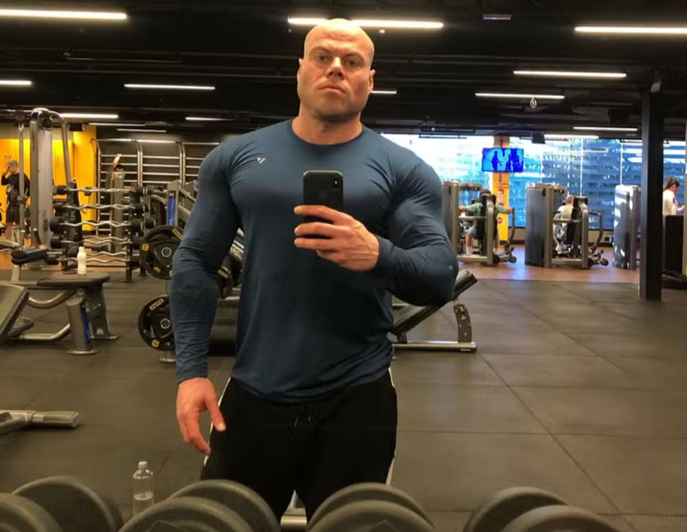 O fisiculturista Valter Aita posando sério para foto no espelho