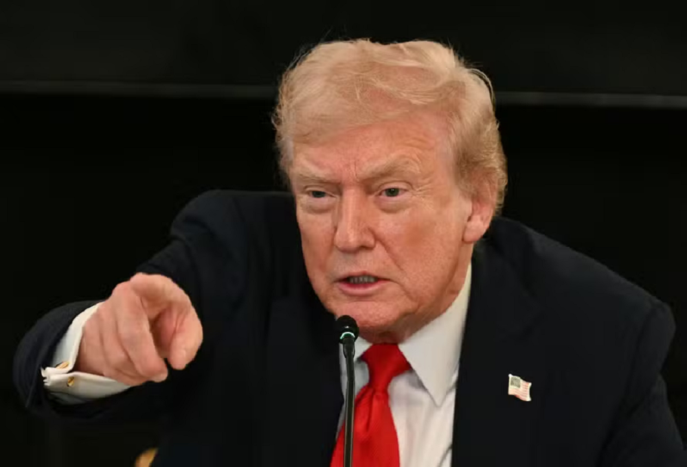O presidente dos EUA, Donald Trump, sério, apontando pra frente