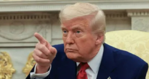 Donald Trump olhando para o lado e apontando, sério