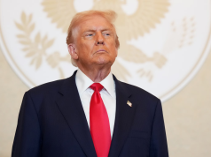 Donald Trump com expressão séria, olhando pra cima