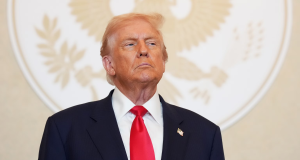 Donald Trump com expressão séria, olhando pra cima