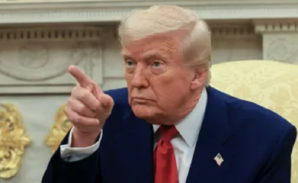 Donald Trump olhando para o lado e apontando, sério