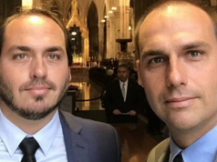 Carlos Bolsonaro (PL) e Eduardo Bolsonaro (PL) olhando para a câmera, sérios, lado a lado