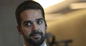 Eduardo Leite em close, sério, com o olhar para o lado