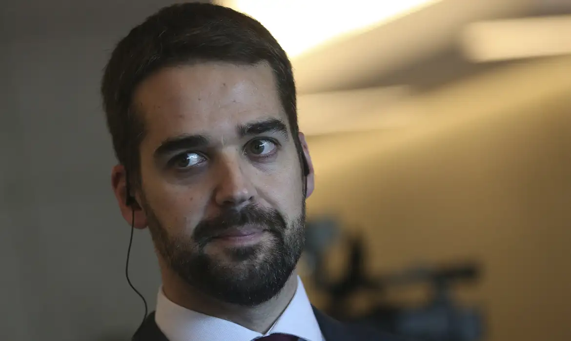 Eduardo Leite em close, sério, com o olhar para o lado