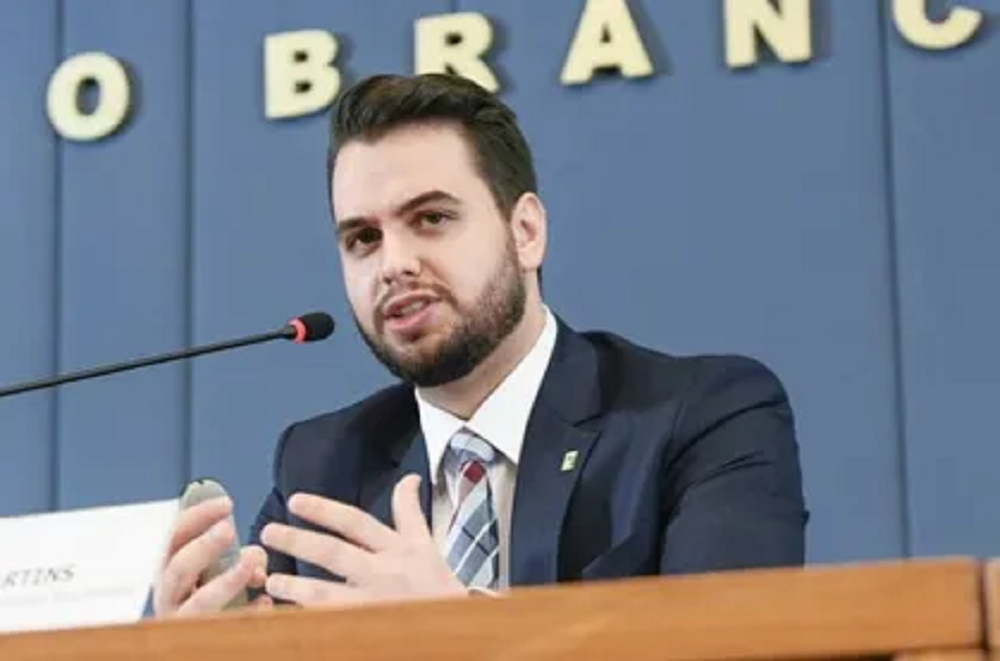 Filipe Martins sério, falando em microfone e gesticulando