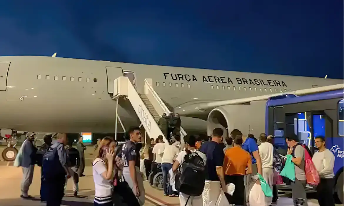 Pessoas aglomeradas perto de avião da Força Aérea Brasileira