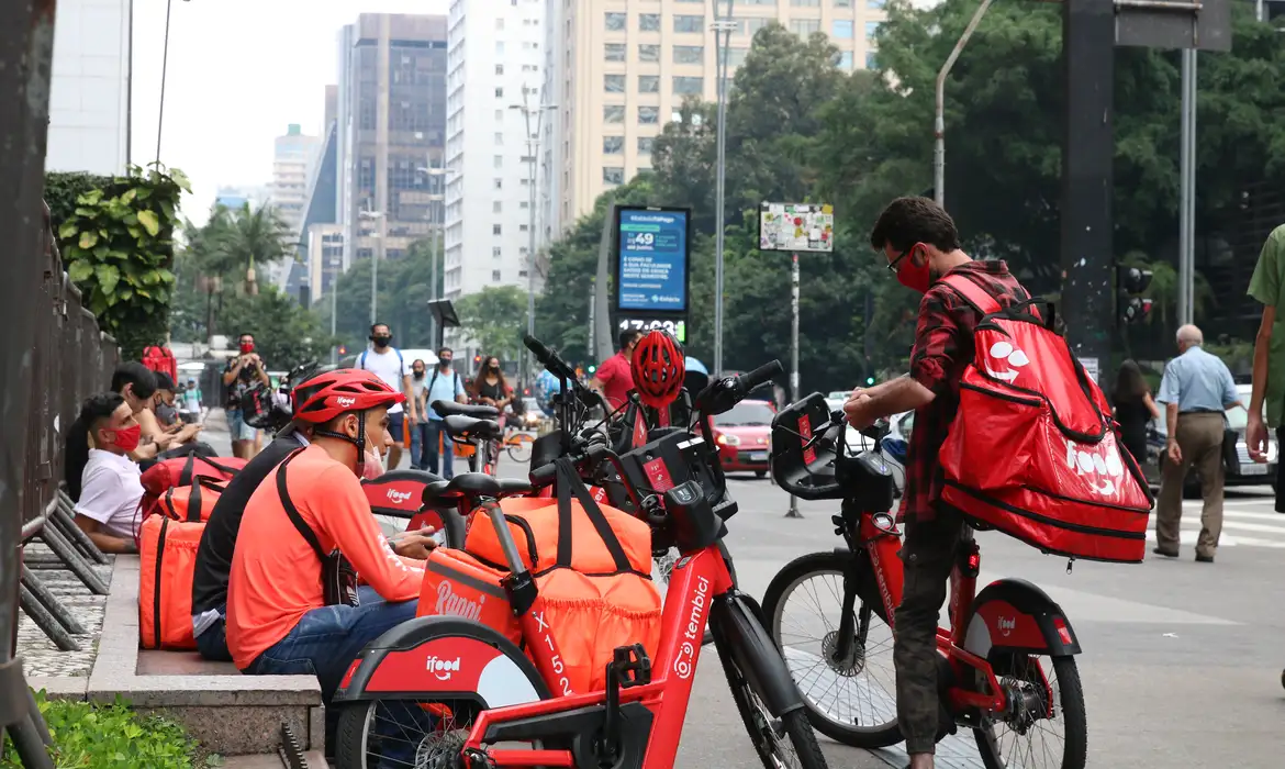 Entregadores com mochilas de aplicativo