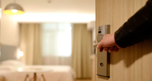 Mão abrindo porta de quarto