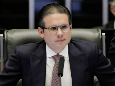 O presidente da Câmara, Hugo Motta, sério, de óculos, sentado, sem olhar para a câmera