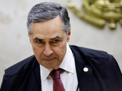 Luís Roberto Barroso com a cabeça baixa e sorriso tímido