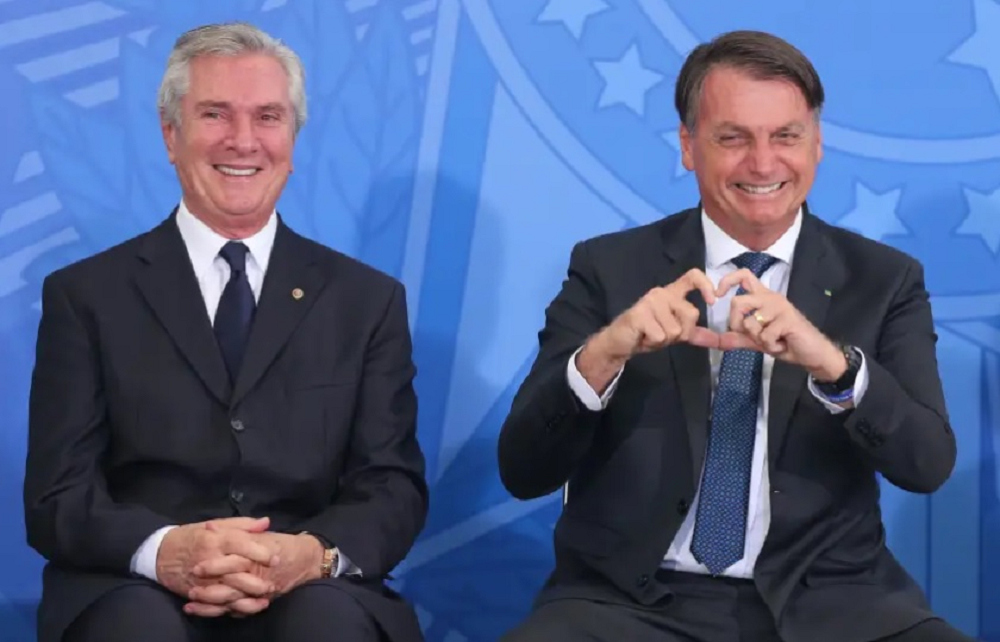 Fernando Collor de Mello e Jair Bolsonaro sorrindo para a câmera