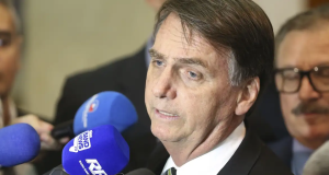 O ex-presidente Jair Bolsonaro (PL) em entrevista antiga, falando em microfones sem olhar para a câmera, sério