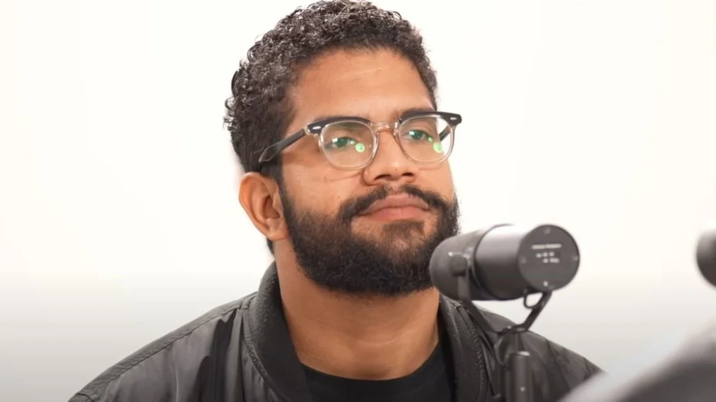 O influencer Jones Manoel de óculos, sério, sem olhar para a câmera