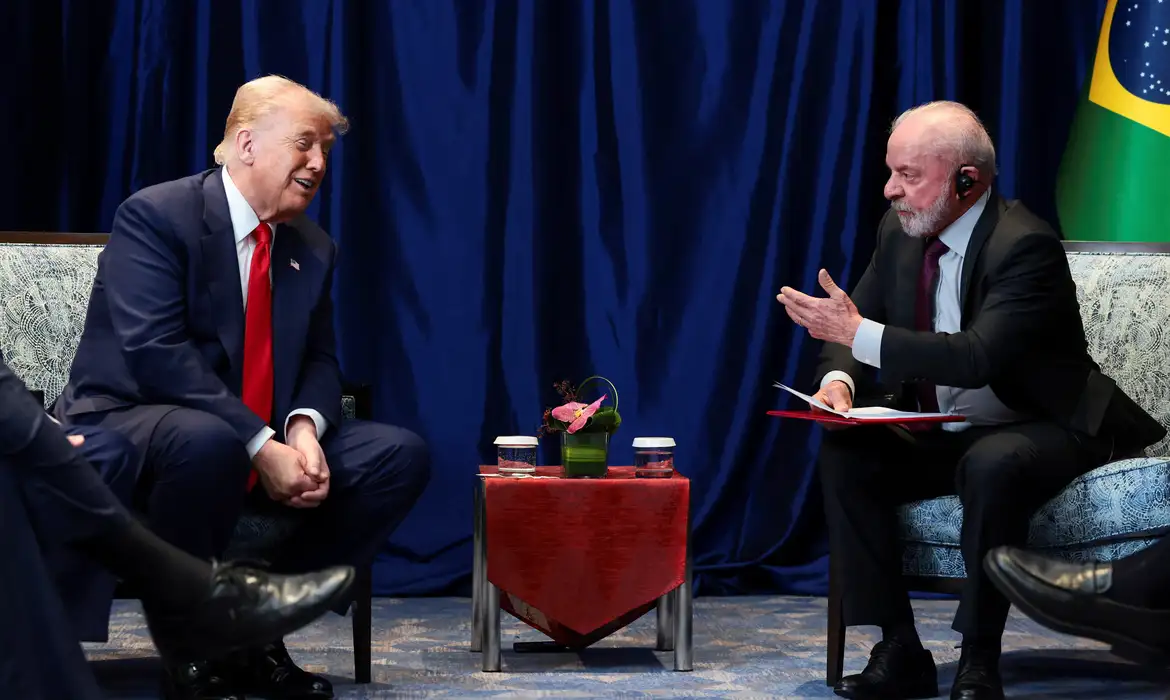 Donald Trump e Lula sentados frente à frente, falando