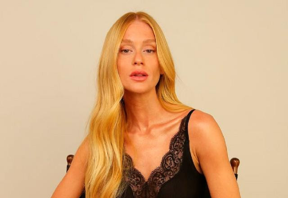 Marina Ruy Barbosa de cabelo loiro e solto, de roupa de alcinha preta, fazendo carão para a câmera