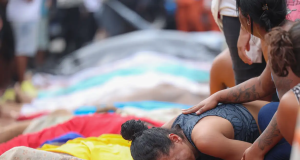 Mulher chorando perto de corpos de mortos em operação policial