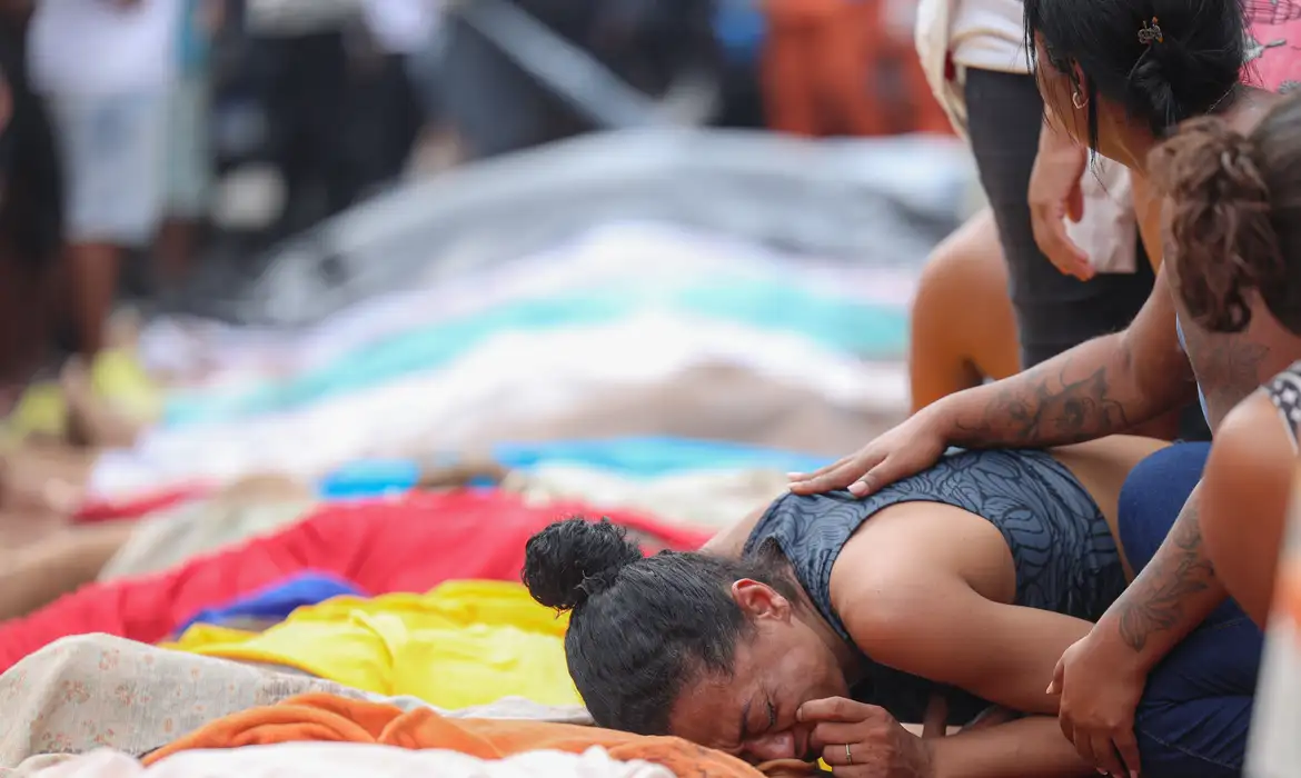 Mulher chorando perto de corpos de mortos em operação policial