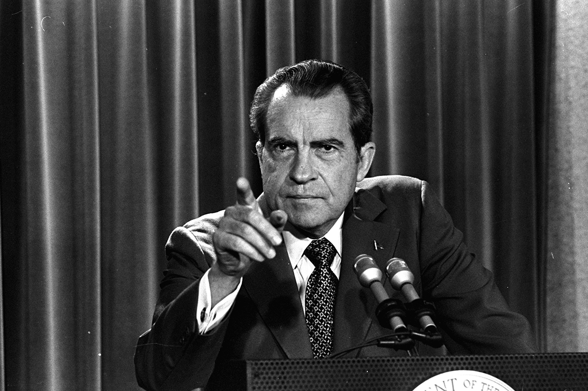 Richard Nixon em foto em preto e branco, olhando e apontando pra frente, sério